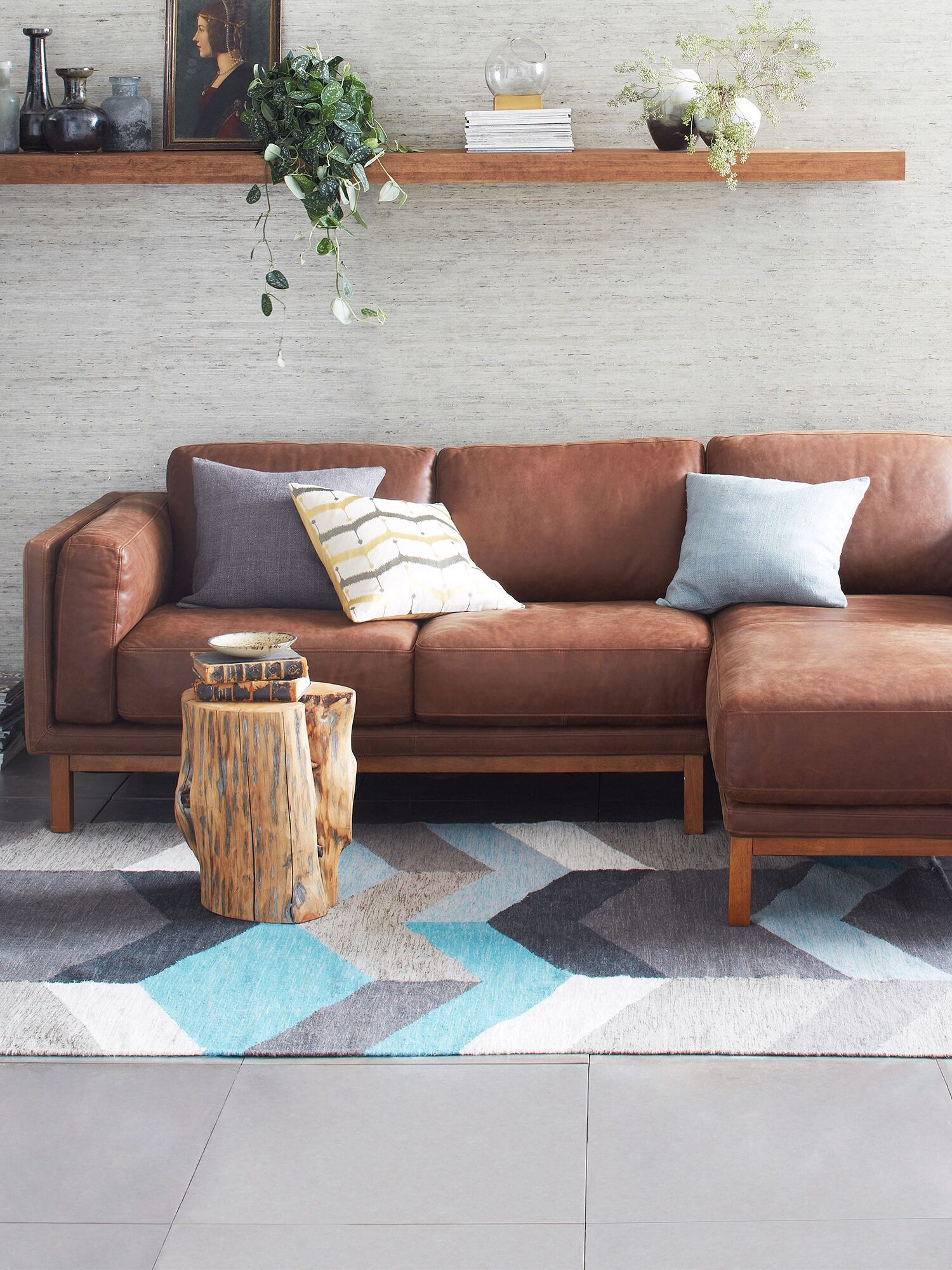 A brown leather West Elm sectional in a living room.
