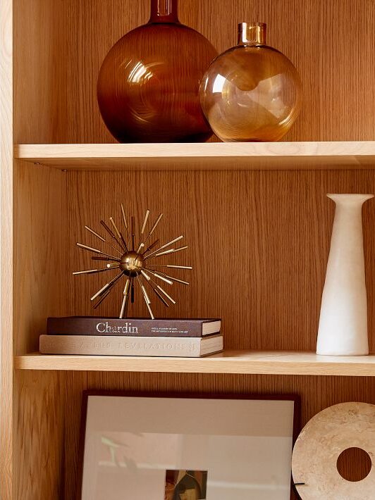 Various decor pieces on a shelved bookcase by West Elm. 