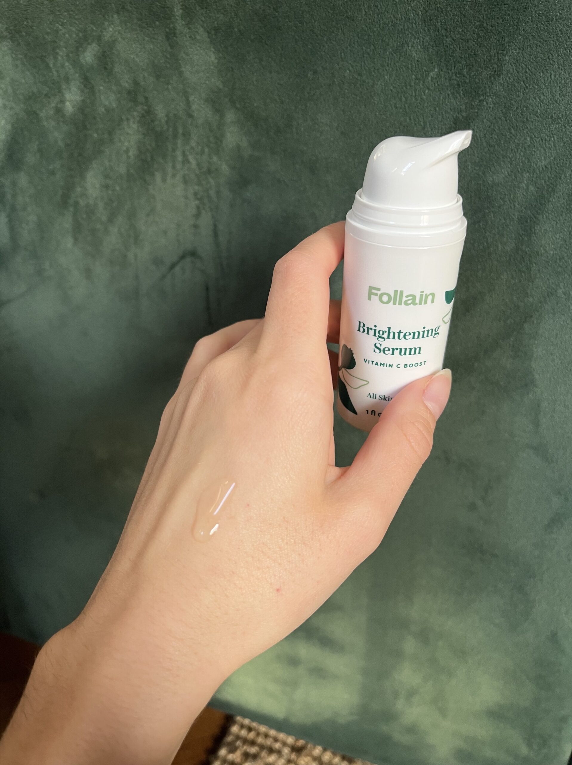 A hand holding Follain Brightening Serum