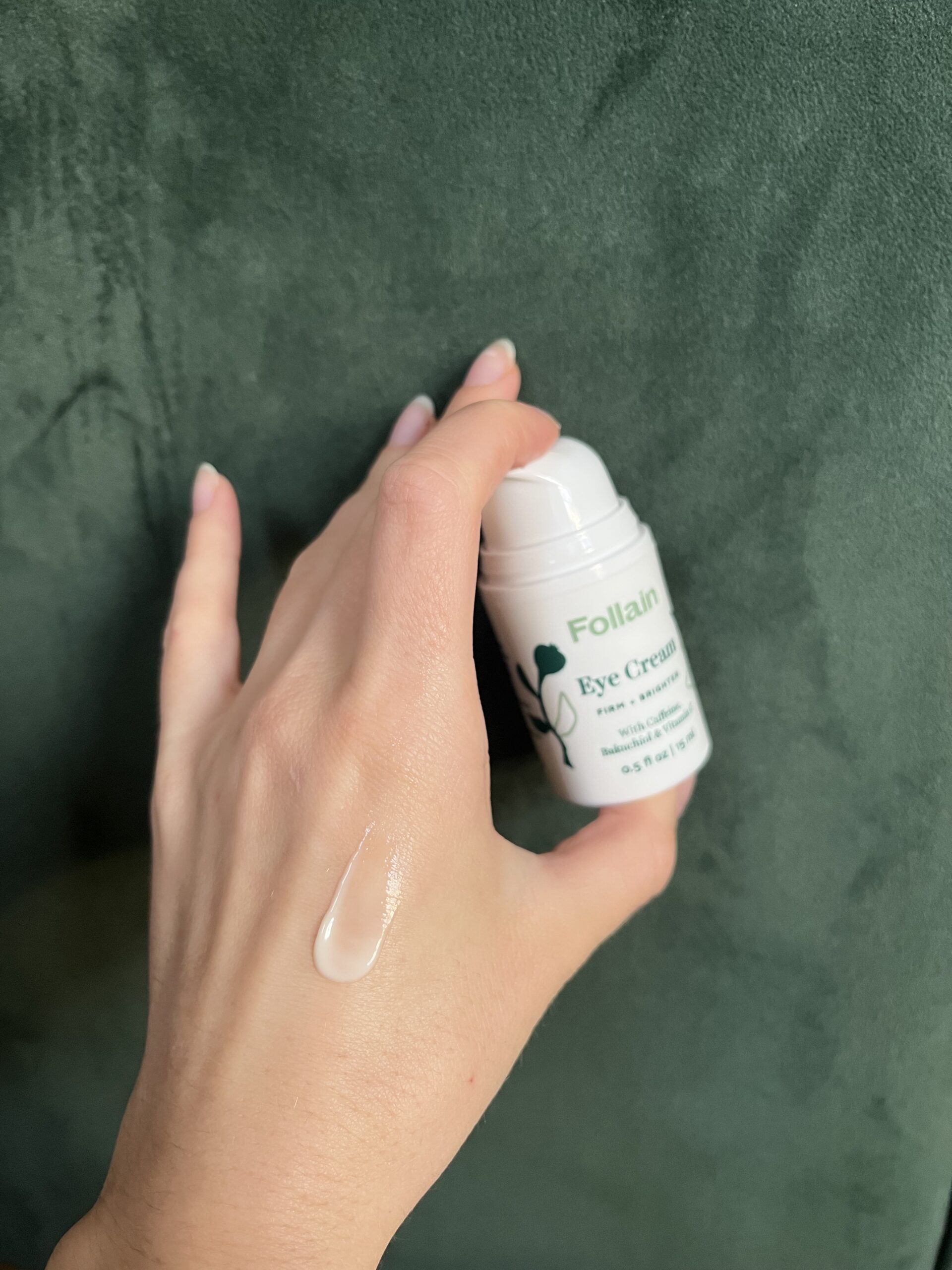 A hand holding Follain Eye Cream