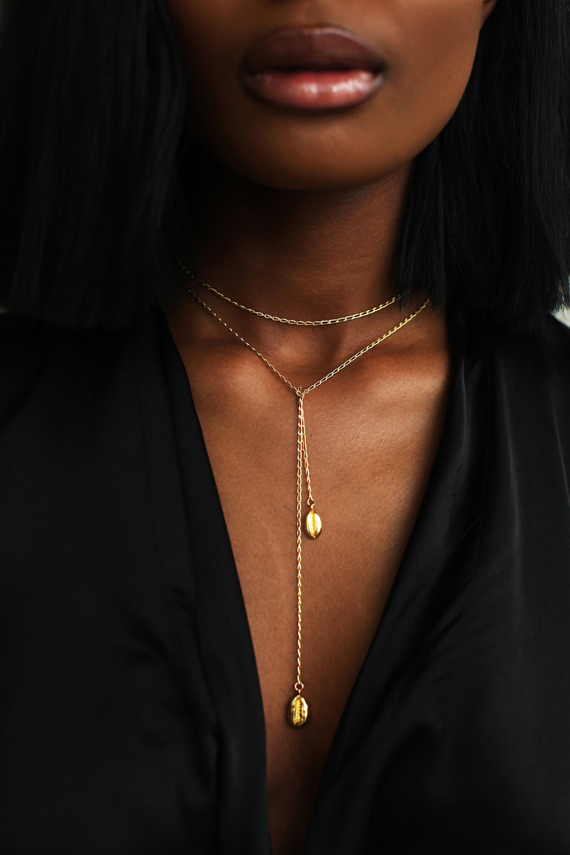 A close up shot of a model wearing a wraparound gold necklace by Etsy shop Omi Woods. 