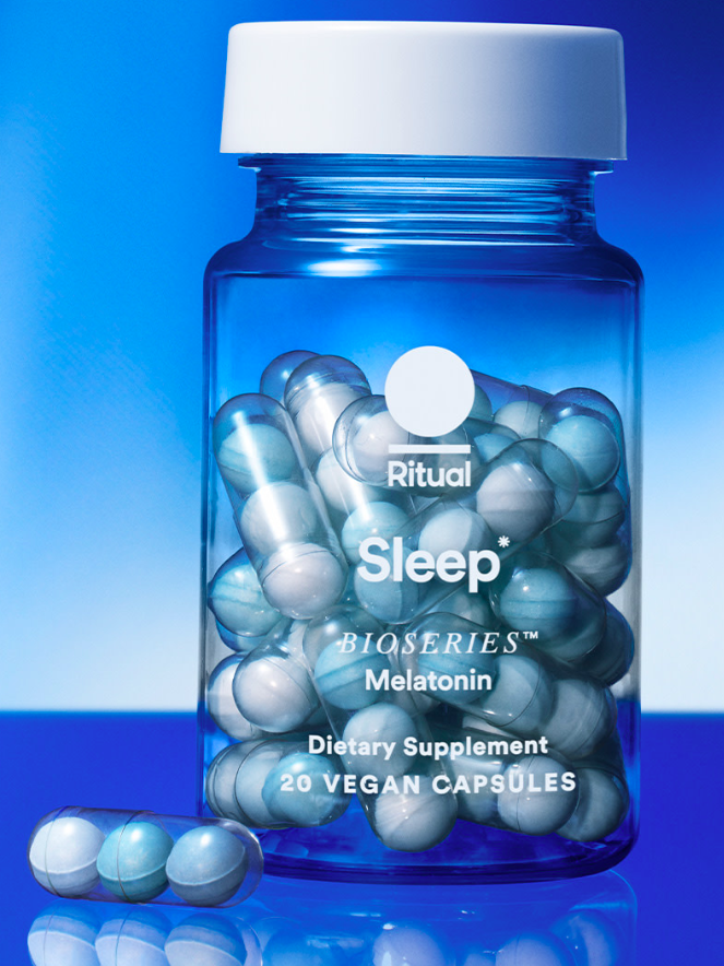 A filled glass bottle of Ritual Sleep Bioseries Melatonin with a capsule on the outer left of the bottle. 