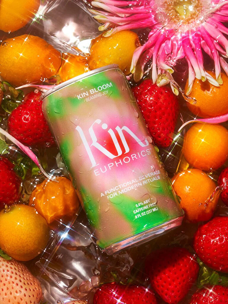 A can of Kin Euphorics on a bed of fruit and flowers.
