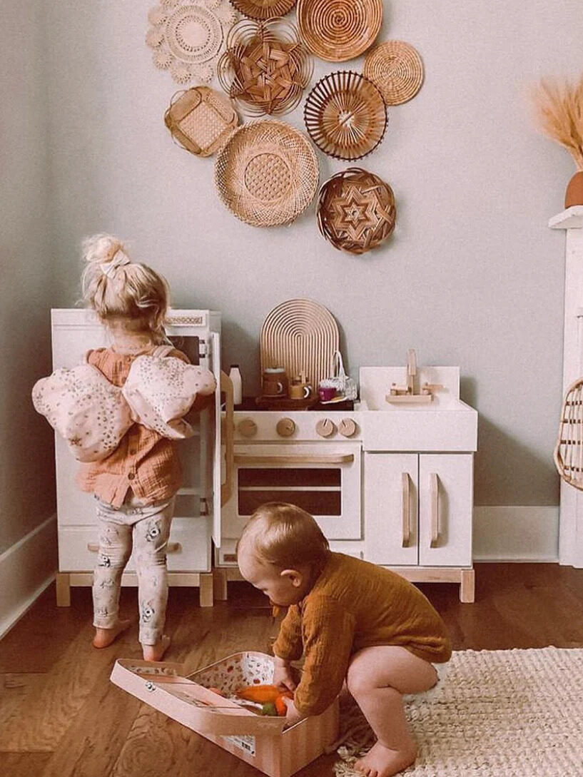 Two children playing with Milton & Goose's Montessori play kitchen. 