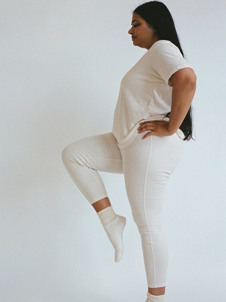 A model wearing Pansy organic cotton leggings in white.