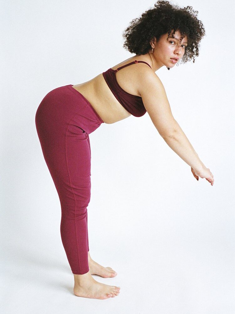 A model wearing Pansy organic cotton leggings in magenta.