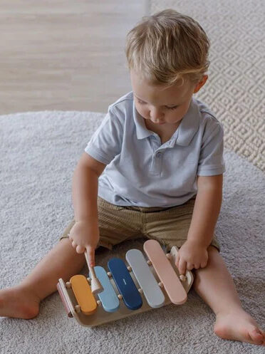 A child playing with a Plantoy Montessori xylophone.