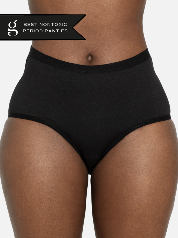 A close up shot of a model wearing The Period Company's black period underwear. The Good Trade's sticker for "Best Nontoxic Period Panties" is in the top left hand corner.