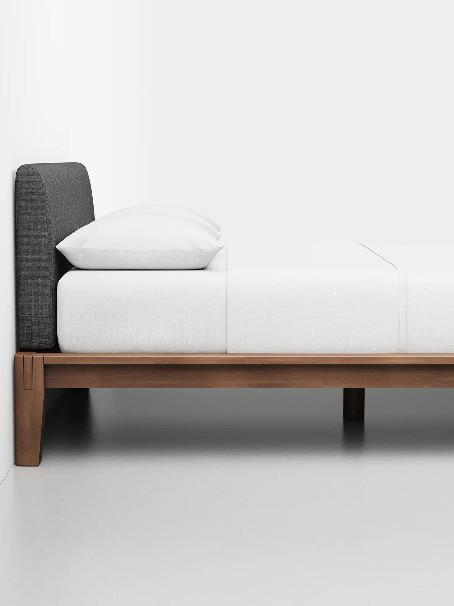 A wooden upholstered bed frame by Thuma.