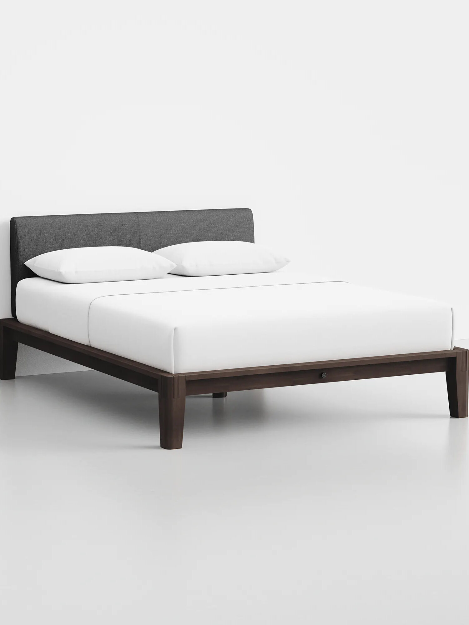 A wooden upholstered bed frame by Thuma.