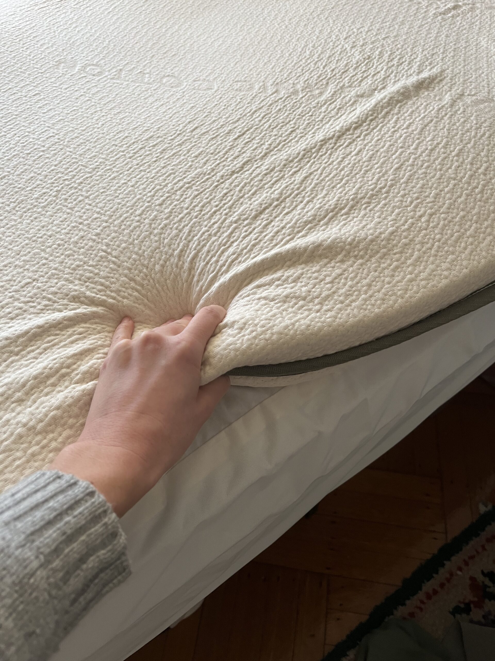 Our editor testing the mattress topper from Avocado