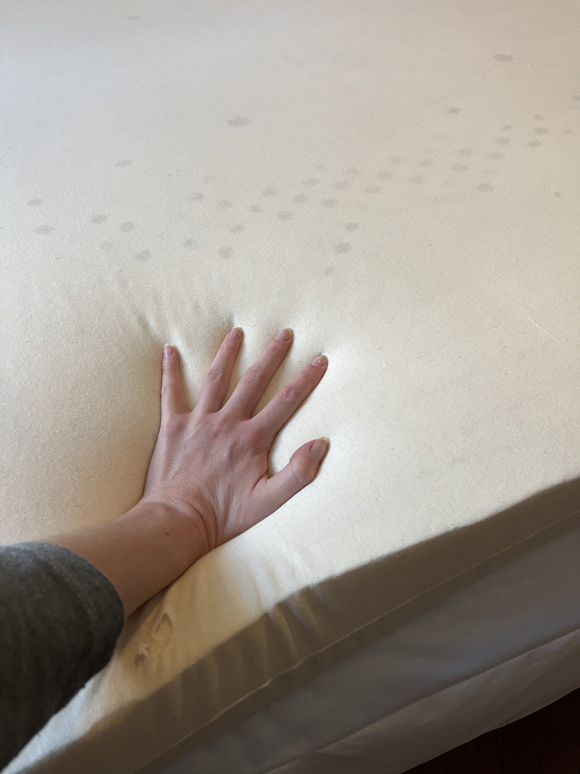 Our editor testing the mattress topper from Brentwood Home