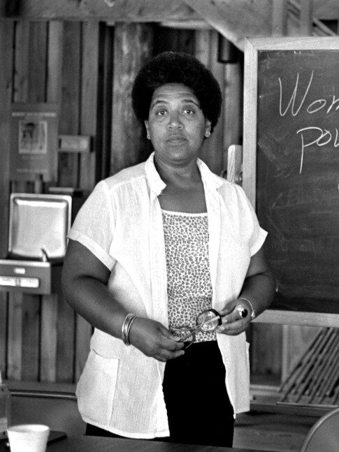 A black and white portrait of Audre Lorde.