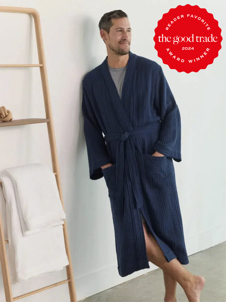 A model wearing an Avocado robe in navy while leaning against a wall. The TGT 2024 Award Winner Badge is on the right corner of the image. 
