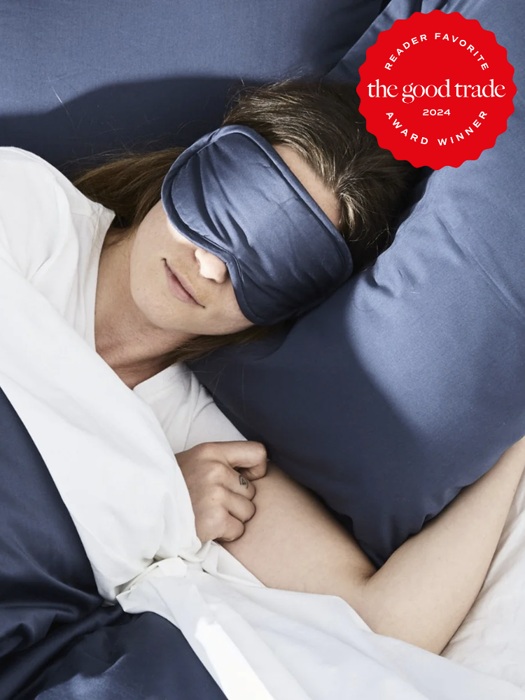 A model wears a Coyuchi sleep mask in bed. The TGT 2024 Award Winner Badge is on the right corner of the image.