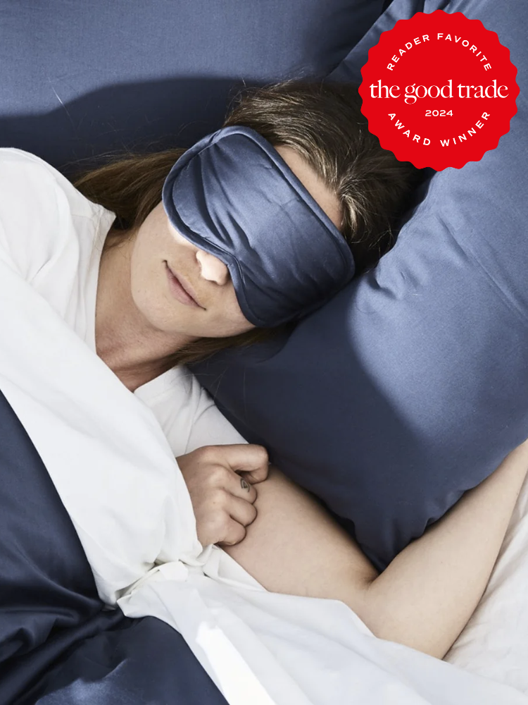 A model wears a Coyuchi sleep mask in bed. The TGT 2024 Award Winner Badge is on the right corner of the image. 