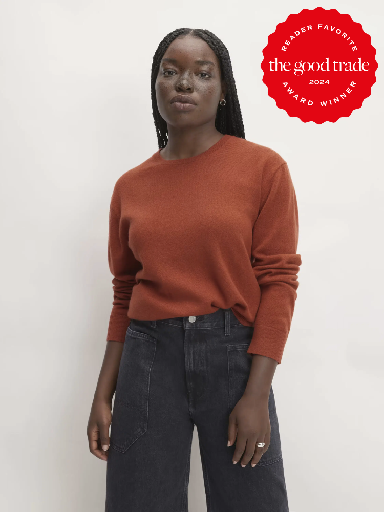 A model wearing a dark red-orange cashmere sweater from Everlane.