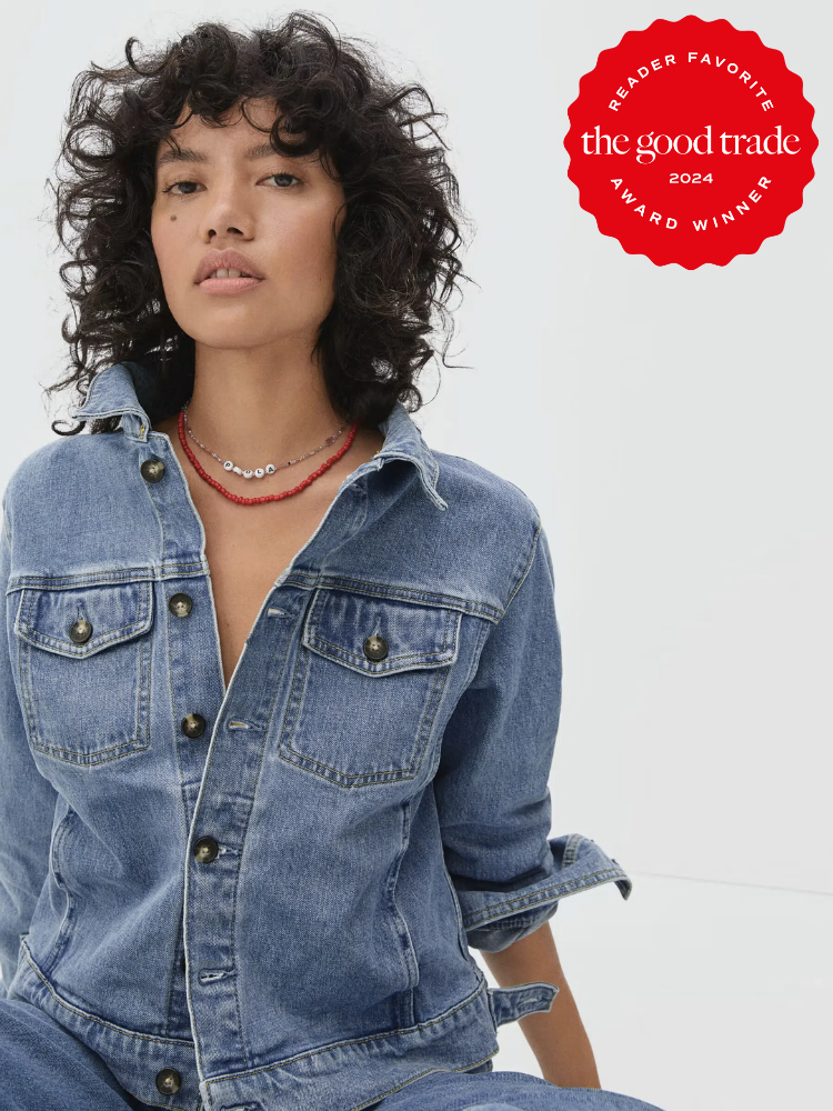 Model wearing an Everlane Sustainable Denim Jacket that's half buttoned up with a red necklace