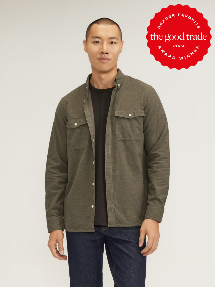 A model wearing a green flannel button down from Everlane. 