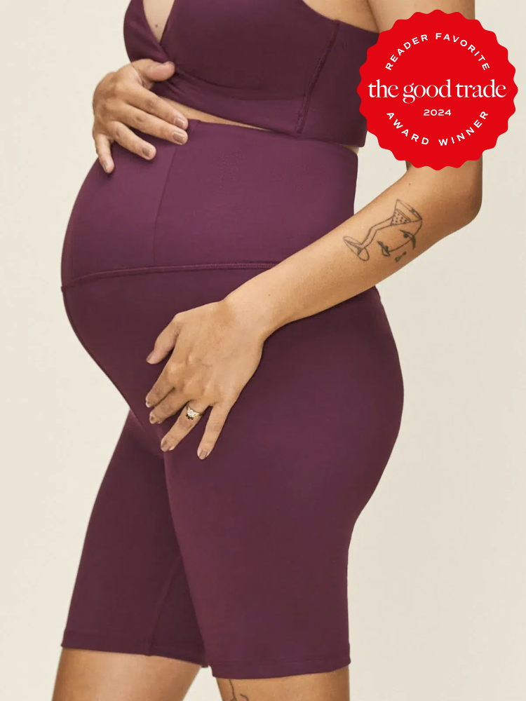 Pregnant model wears maroon high waisted biker shorts. The TGT 2024 Award Winner Badge is on the right corner of the image.