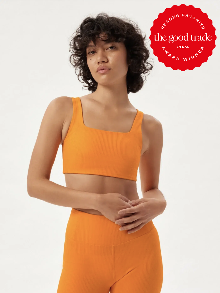 A petite model in a Girlfriend Collective activewear set. The TGT 2024 Award Winner Badge is on the right corner of the image. 