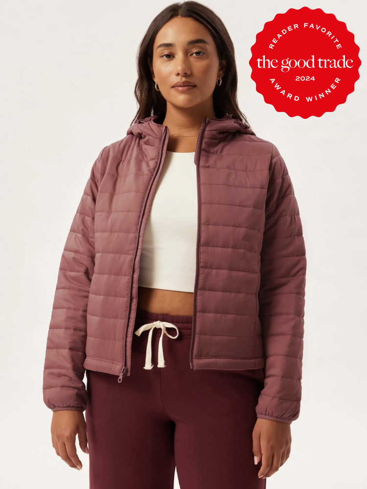 A model wearing a magenta puffer jacket from Girlfriend Collective. The TGT 2024 Award Winner Badge is on the right corner of the image.