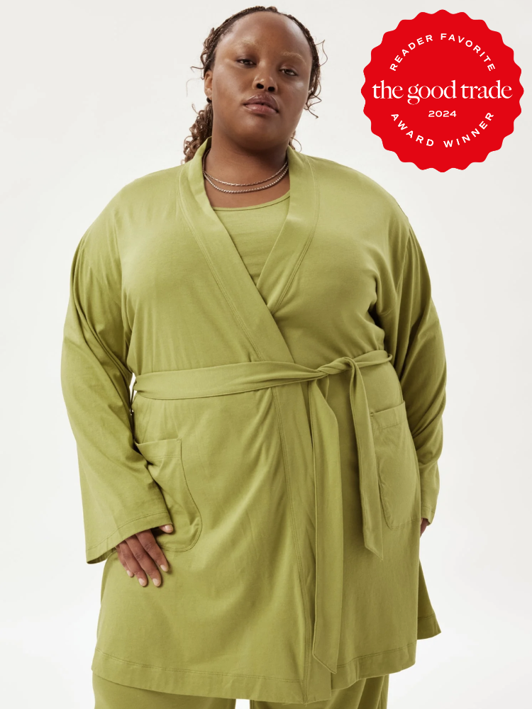A model wearing a Girlfriend Collective robe in lime green. The Good Trade's 2024 Reader Award sticker is on the top right corner.