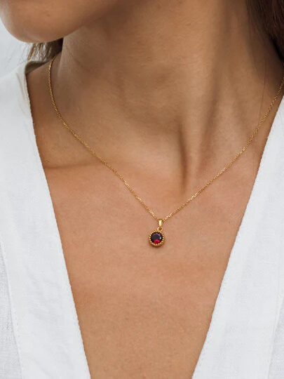A close up shot of a red garnet pendant necklace from Linjer. 