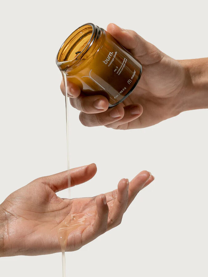 Maude's Burn massage candle being poured onto a hand. 