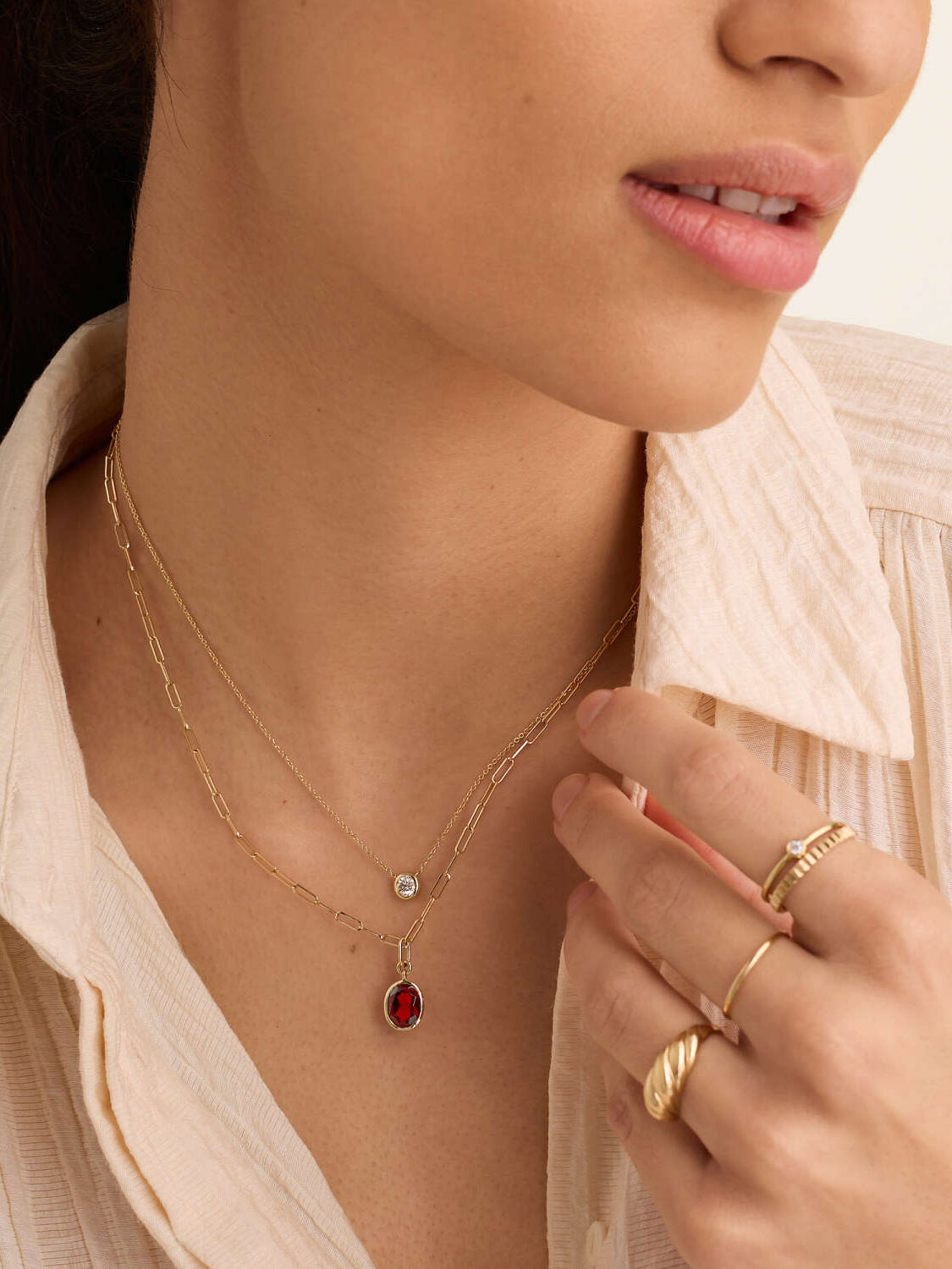 A close up shot of an oval garnet pendant necklace from Mejuri. 