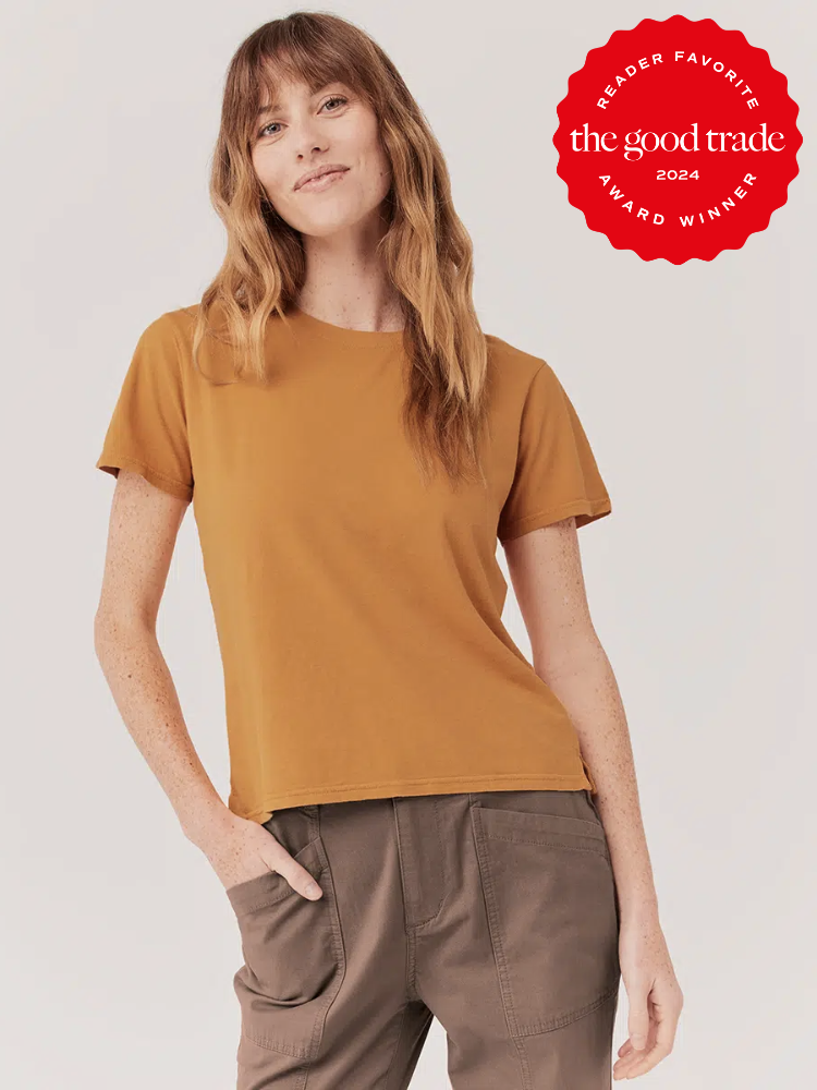 Model wearing a Pact cotton t shirt in orange.
