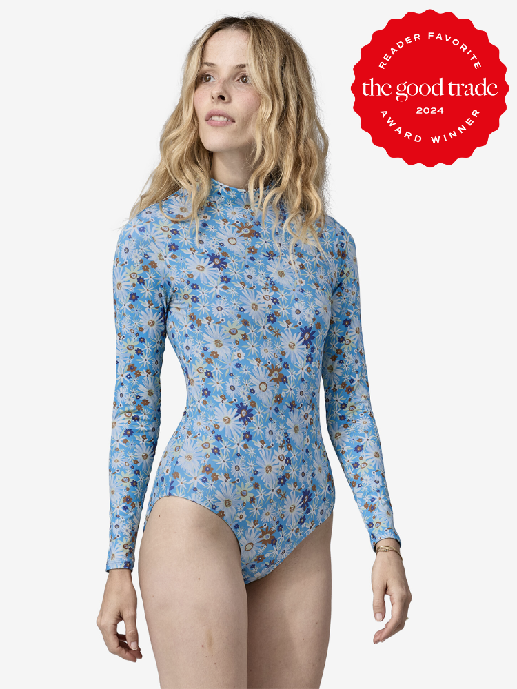 A model wearing a Patagonia high neck one piece swimsuit in blue flower pattern.