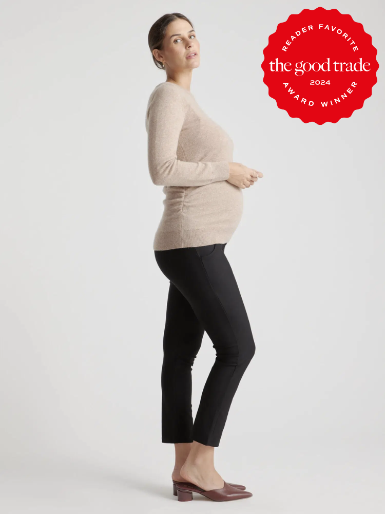 A pregnant model wearing a beige Quince cashmere sweater.