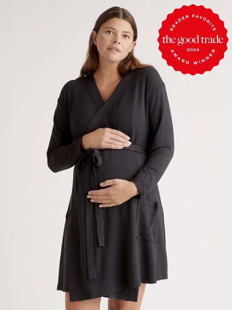 A model who is pregnant wearing Quince's maternity robe in black. The TGT 2024 Award Winner Badge is on the right corner of the image. 
