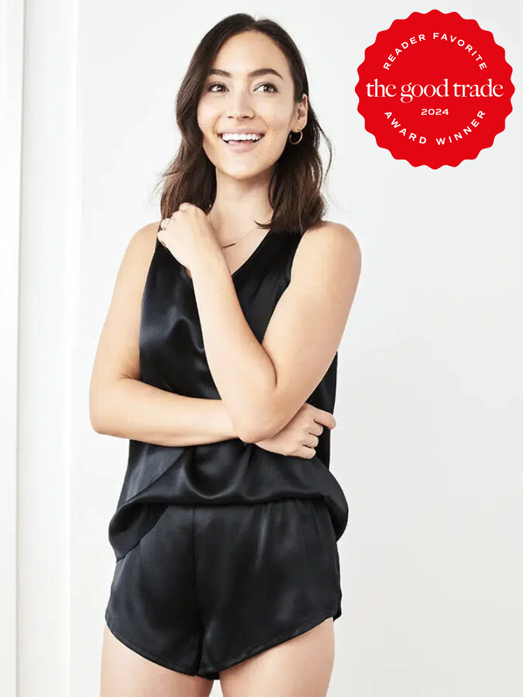 A model wearing a black silk shorts romper from Quince. The TGT 2024 Award Winner Badge is on the right corner of the image. 
