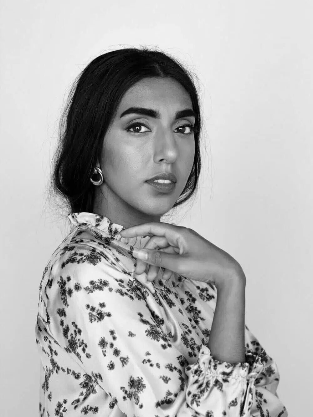 A black and white portrait of Rupi Kaur.