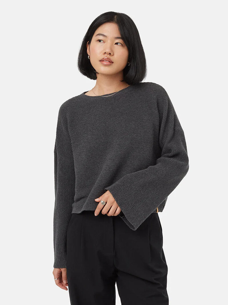 A model wearing a wide sleeve grey sweater from tentree.