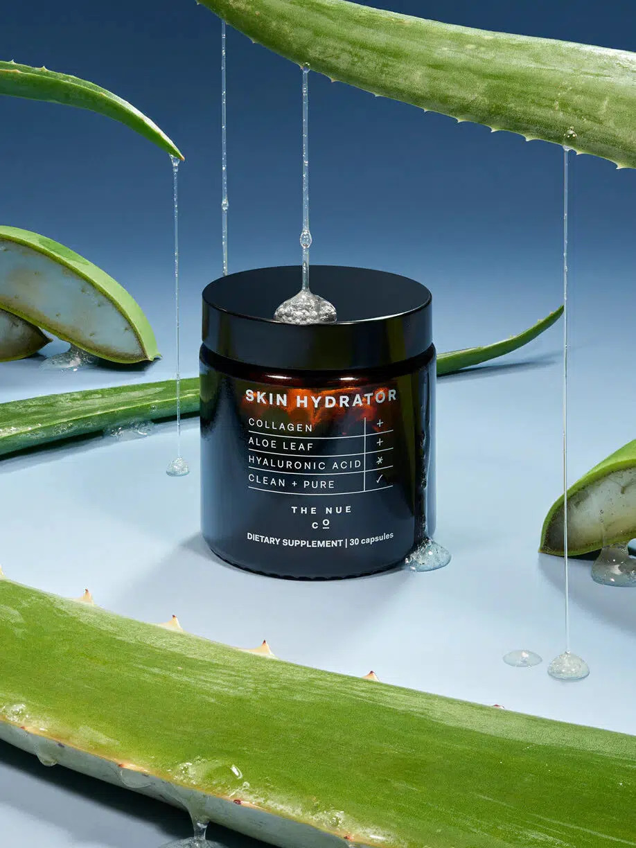 A jar of The Nue Co.'s Skin Hydrator, surrounded by aloe leaves. 
