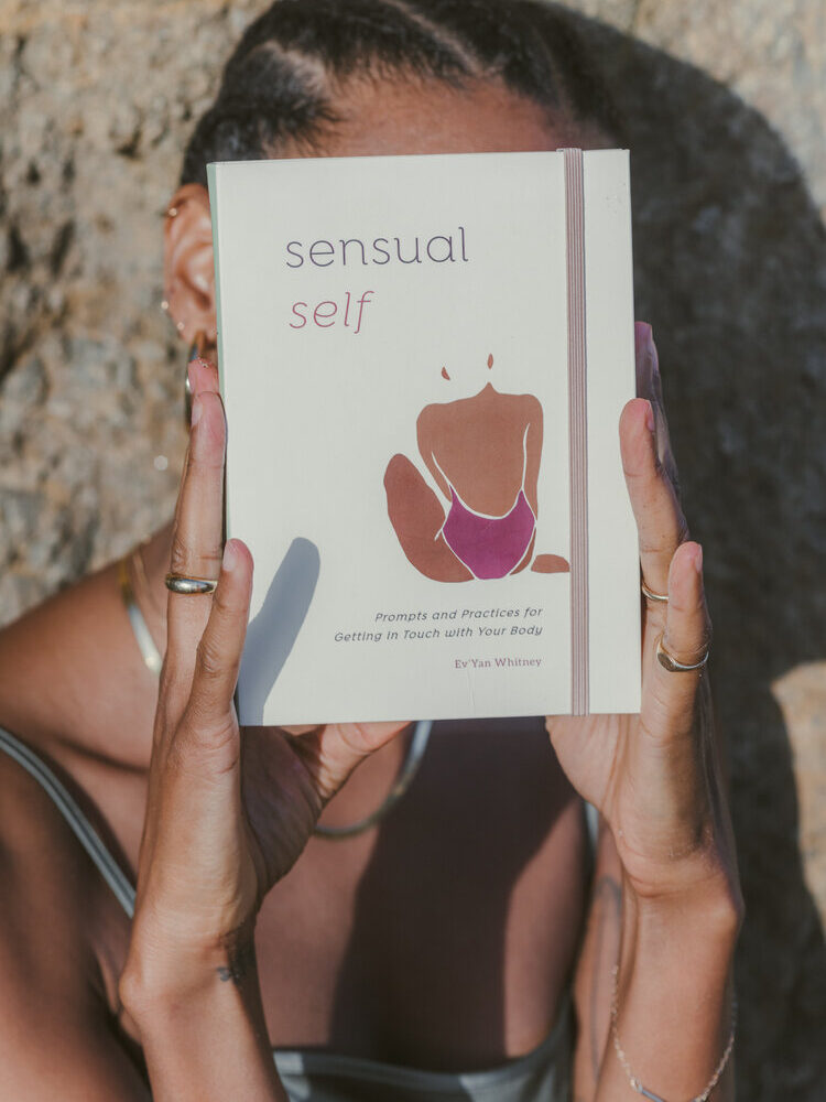Ev’Yan Whitney holding up her book, Sensual Self.