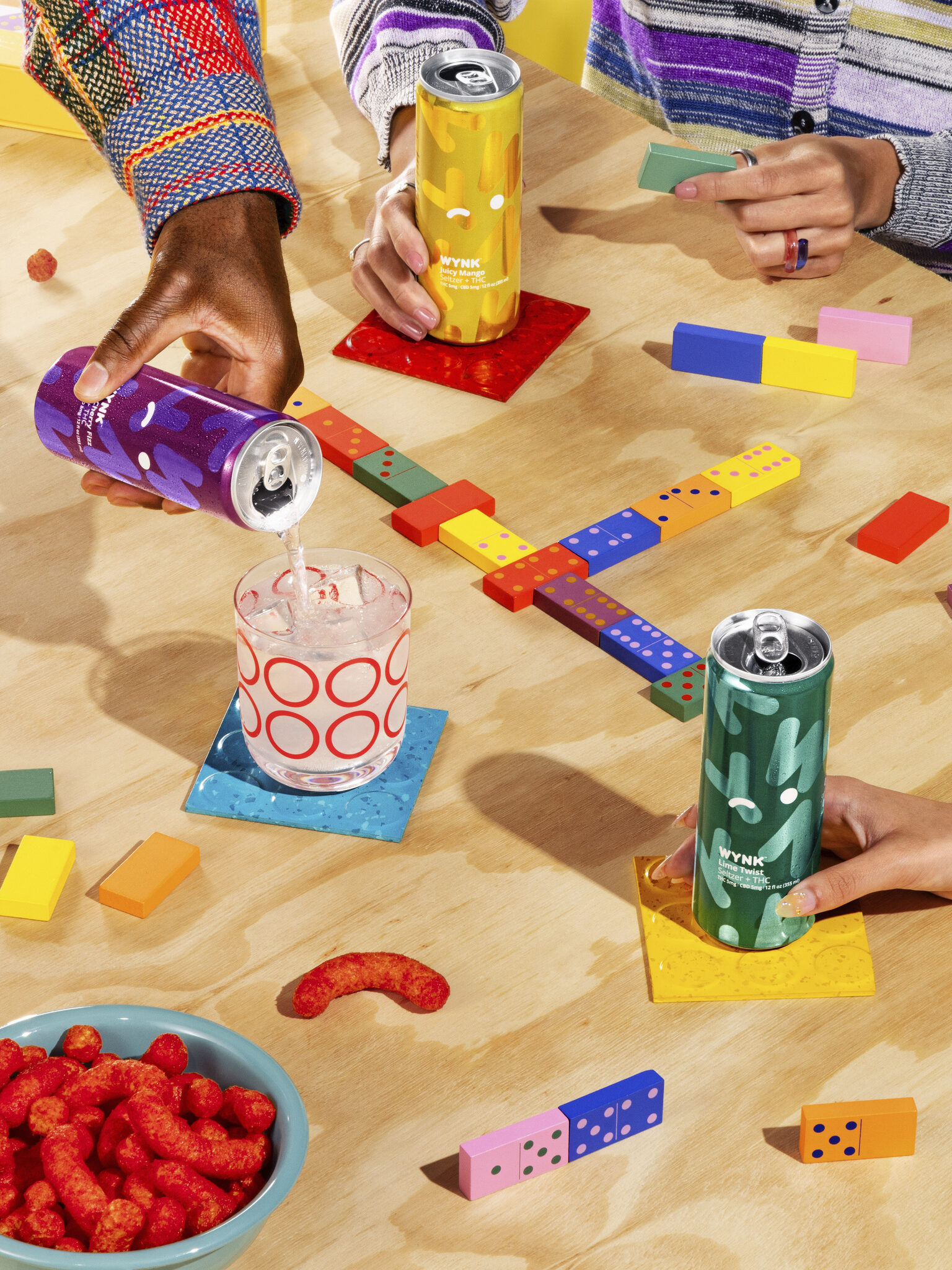 WYNK drinks being held and poured on a game table. 