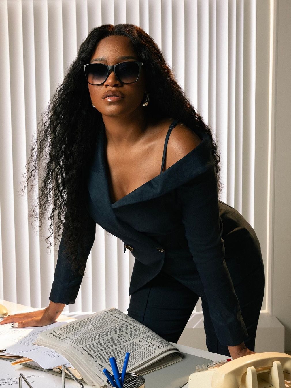 Keke Palmer in a black off shoulder suit set wearing Zenni sunglasses. 