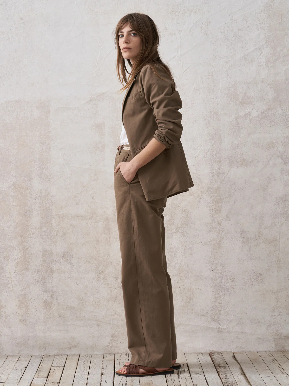 The model is wearing a tan blazer and pants.