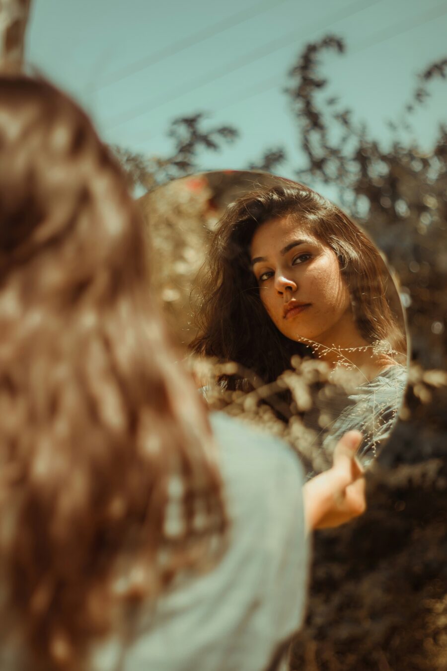 A woman looking at herself in a mirror.