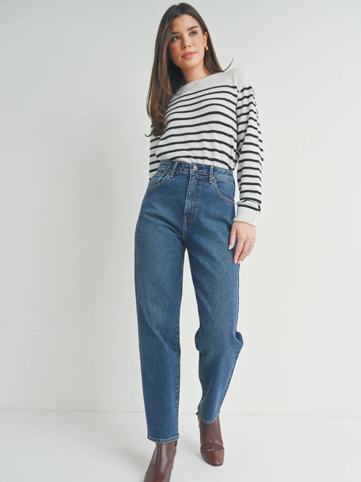 A woman wearing jeans and a striped top.