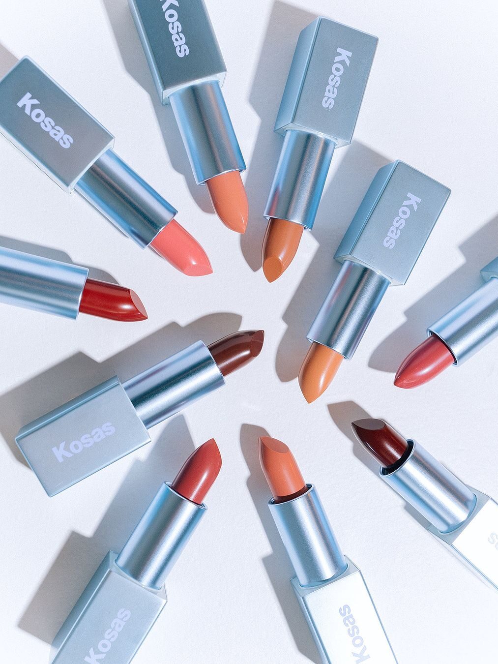 A variety of Kosas lip colors, laid in a circle. 