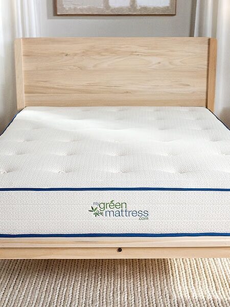 A mattress in a bedroom with a wooden frame.