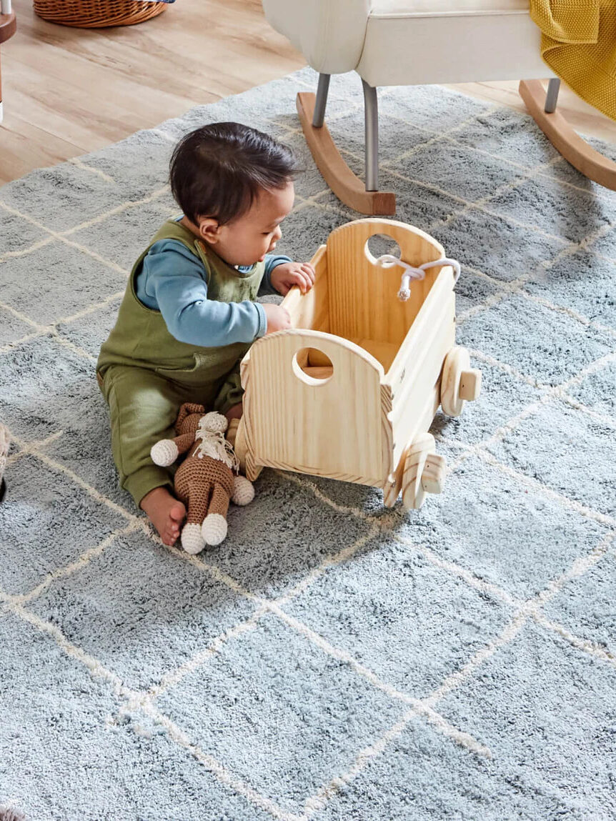 A child playing on a Nestig Rug.