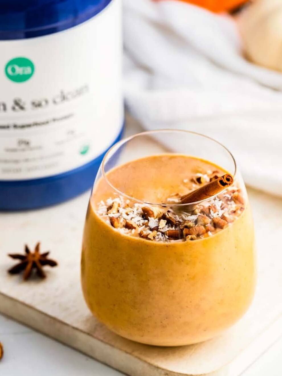 A vanilla chair protein shake in a clear wine tumbler, made with Ora Organic protein. 