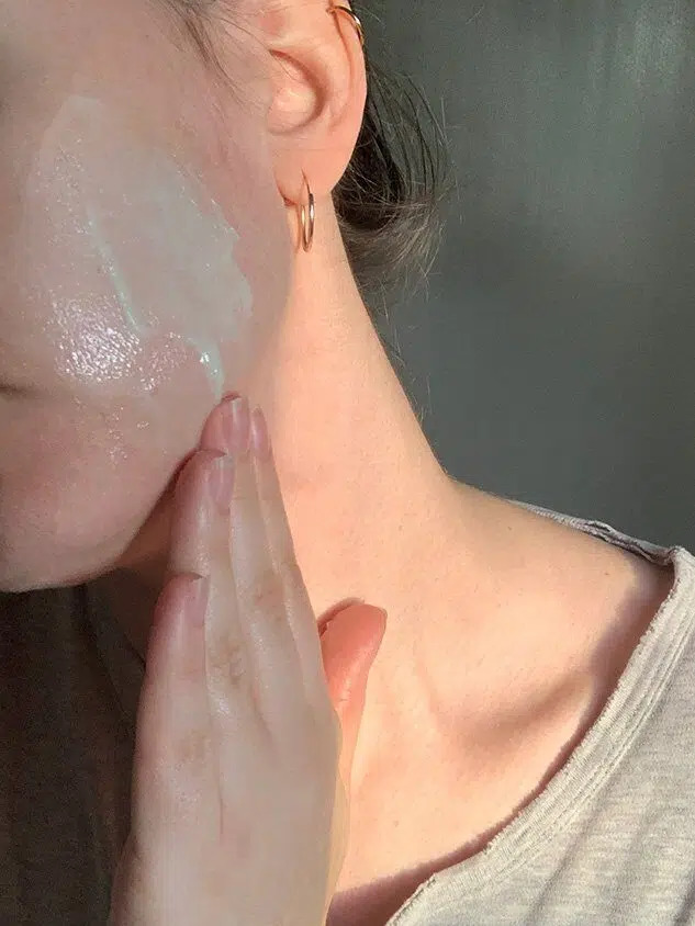 A tgt editor applying OSEA skincare products to their face.  
