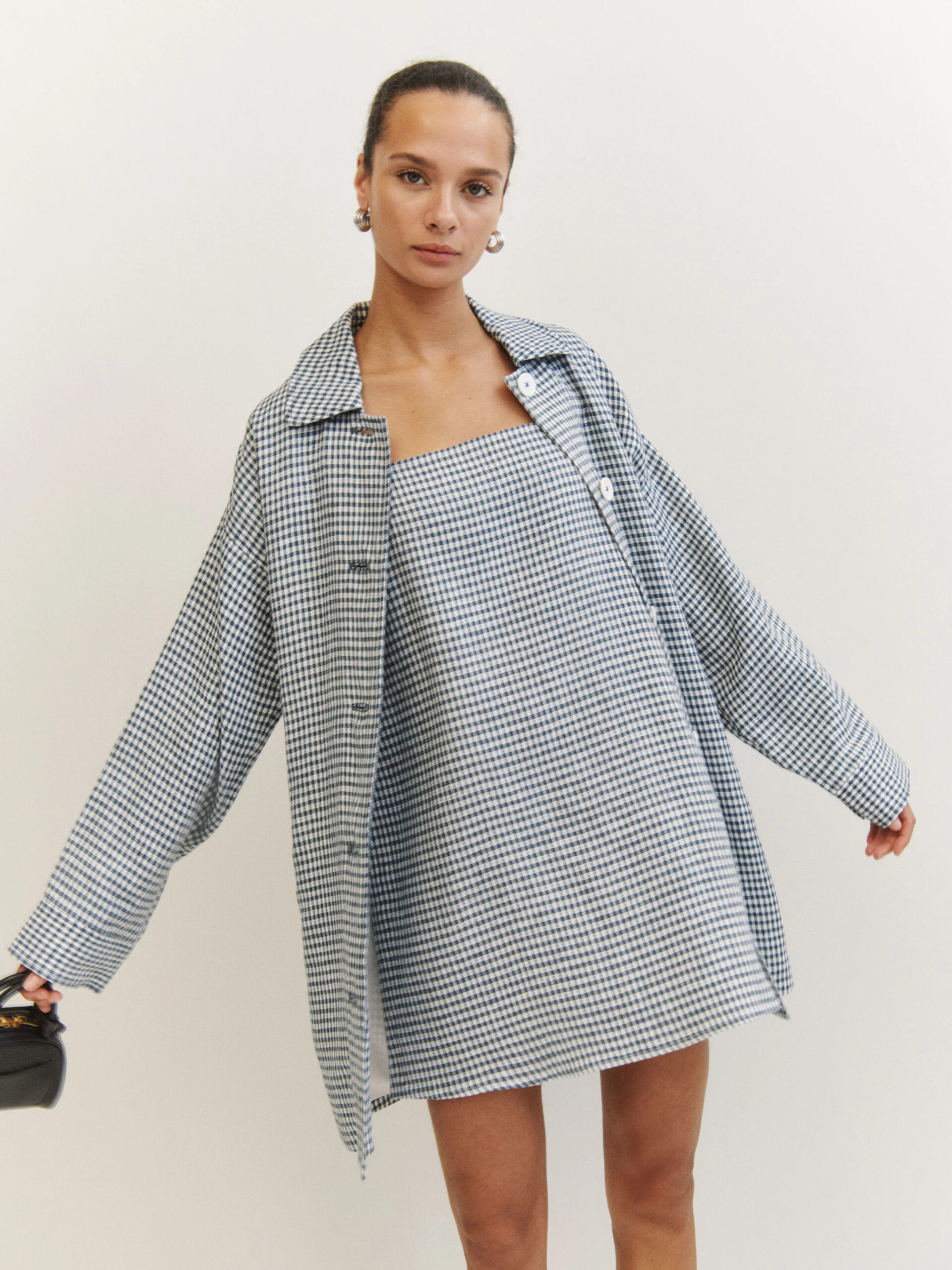 The model is wearing a blue and white checkered shirt dress.